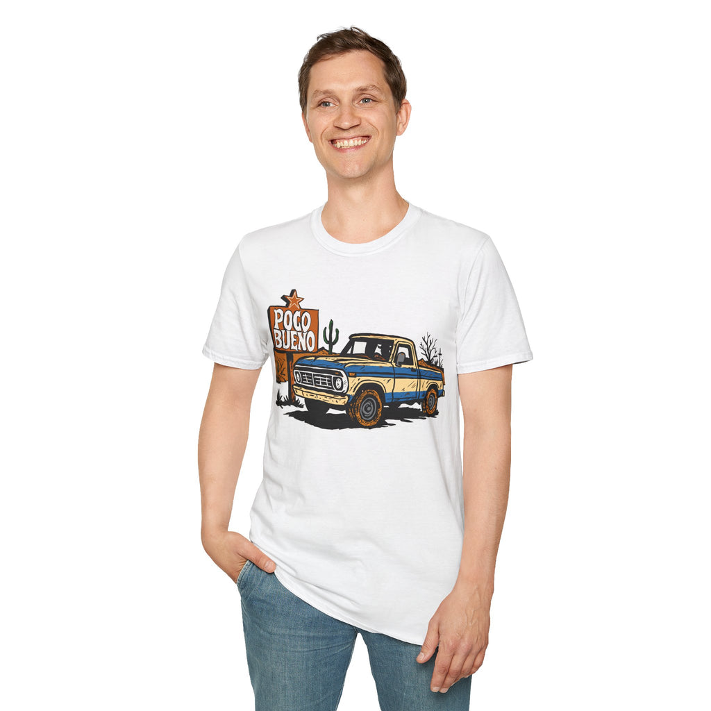 Person wearing a white t-shirt with a graphic design of a truck and 'Poco Bueno' text on desert road sign